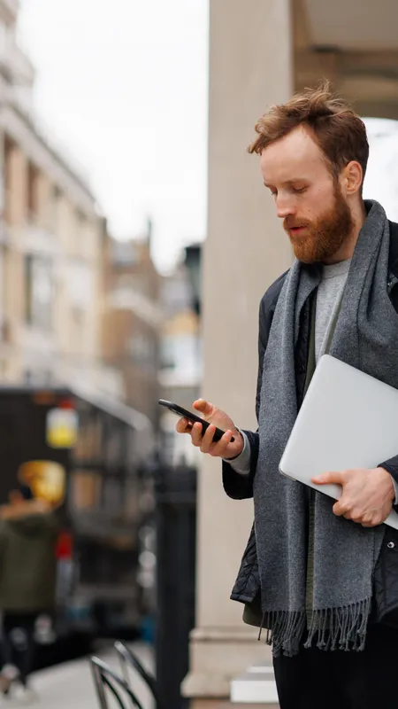 https://cms-assets.foxtons.co.uk/large_bearded_business_man_jacket_scarf_with_laptop_using_smartphone_while_standing_street_near_entrance_building_9742f1dcf1.webp